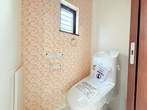 ウォシュレット機能付きのトイレ。収納もあり実用性も兼ね備えた造り。