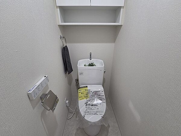 ウォシュレット機能付きのトイレ。収納もあり実用性も兼ね備えた造り。
