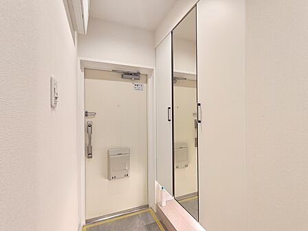 大きな靴棚を配した玄関ホール。靴棚に設置した姿見鏡はお出かけ前の身だしなみチェックにお役立てください!