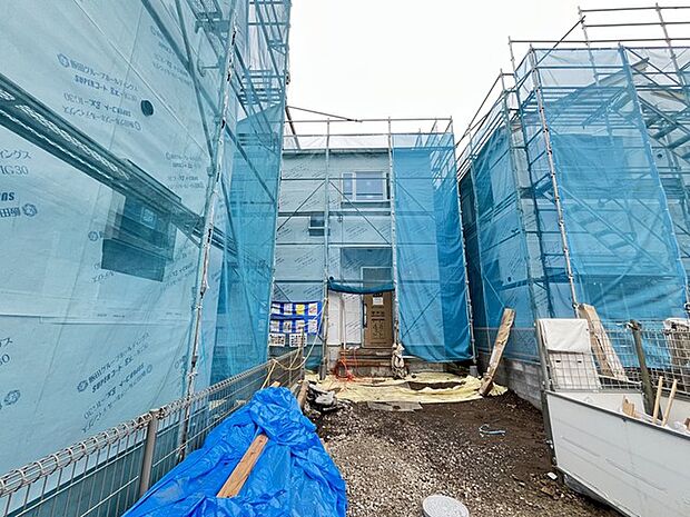 工事の足場に囲まれた現場の様子が伝わり、新しい住まいの完成へと期待が高まる風景です