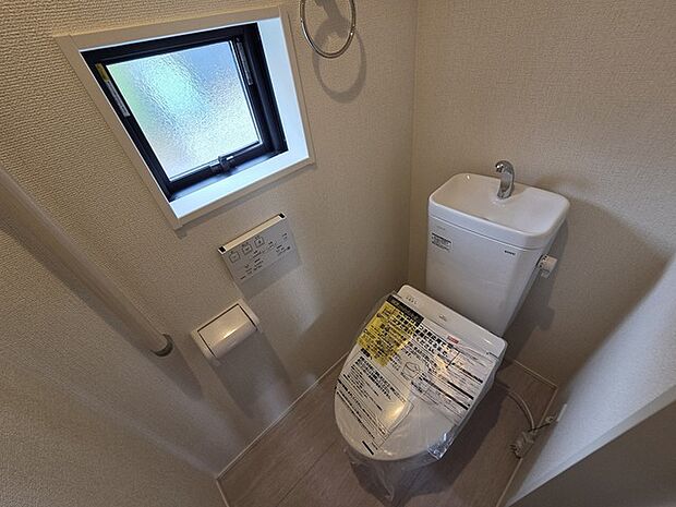 ウォシュレット機能付きのトイレ。換気のしやすい窓付きで、収納もあり実用性も兼ね備えた造り。