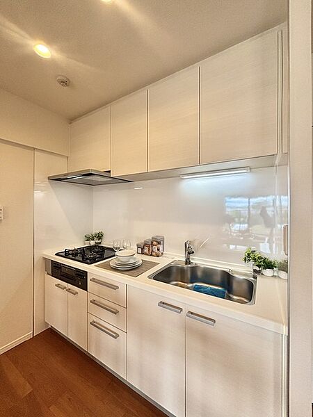 壁付のキッチンは上部に収納が作りやすいのがメリット。空間を有効活用したすっきりとしたデザイン。
