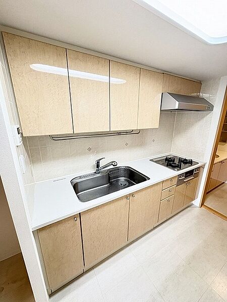 壁付のキッチンは上部に収納が作りやすいのがメリット。空間を有効活用したすっきりとしたデザイン。
