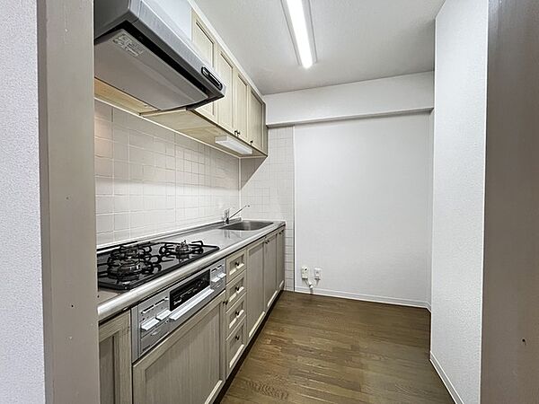 壁付のキッチンは上部に収納が作りやすいのがメリット。空間を有効活用したすっきりとしたデザイン。