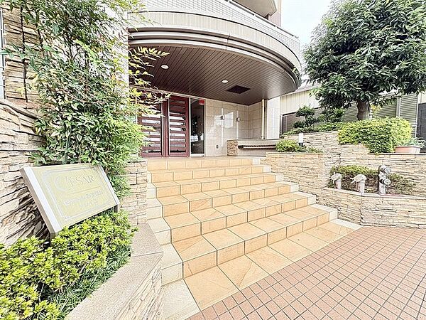タイル貼りの階段と緩やかな曲線を描く庇が、気品あるエントランスを演出します