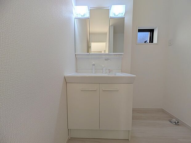 ワイドなボウルにハンドシャワー水栓が付いた洗面化粧台。