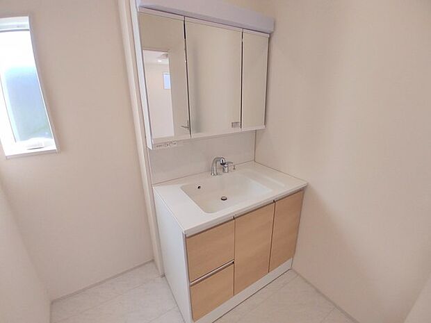 ワイドなボウルにハンドシャワー水栓が付いた洗面化粧台。 