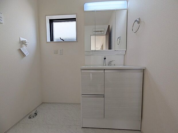 ワイドなボウルにハンドシャワー水栓が付いた洗面化粧台。 