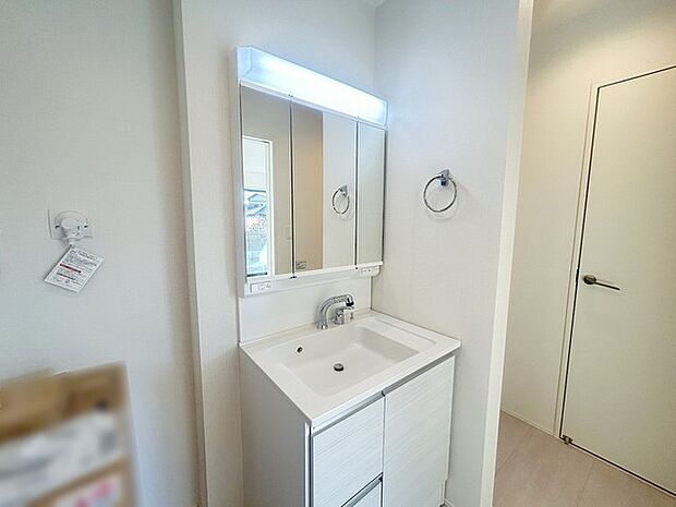 ワイドなボウルにハンドシャワー水栓が付いた洗面化粧台。 