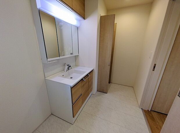 ワイドなボウルにハンドシャワー水栓が付いた洗面化粧台。 