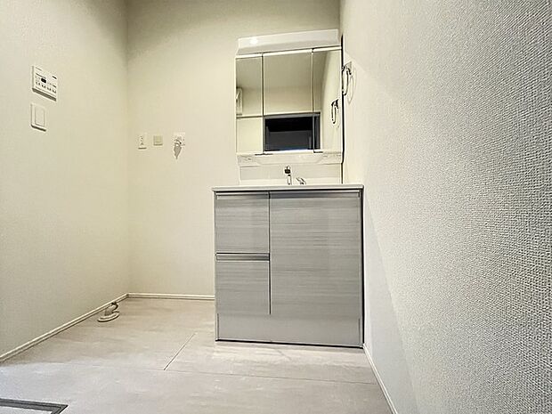 ワイドなボウルにハンドシャワー水栓が付いた洗面化粧台。 