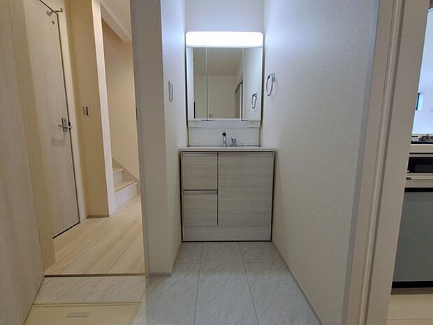 ワイドなボウルにハンドシャワー水栓が付いた洗面化粧台。 