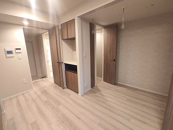 明るい色調の床と木目調の建具が調和し、すっきりとした清潔感を感じさせる室内です。
