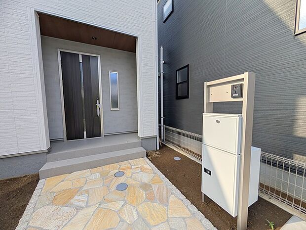 アプローチからの玄関がおしゃれな住宅。出発も帰宅も楽しみになるかも。 
