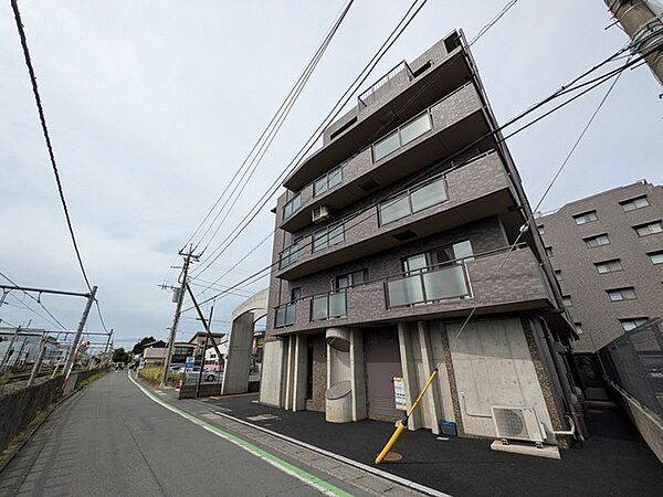 落ち着いた色合いの外観が街並みに馴染み、穏やかな日常を予感させる佇まい