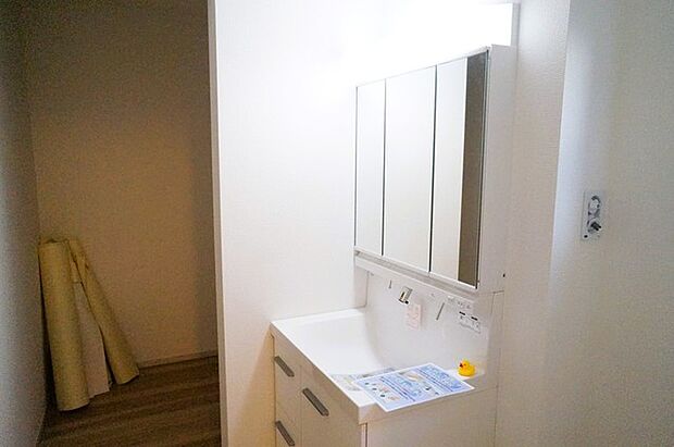 ワイドなボウルにハンドシャワー水栓が付いた洗面化粧台。