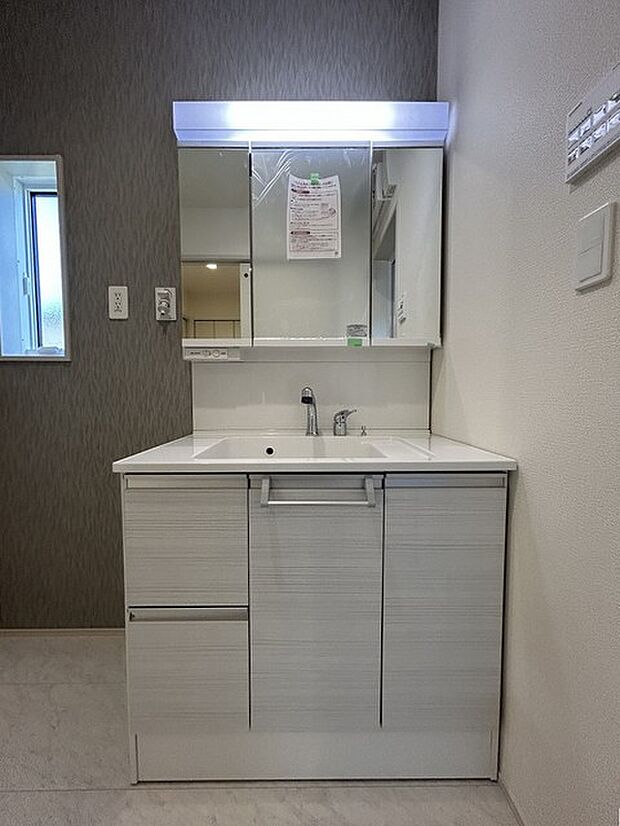 三面鏡を採用した洗面化粧台。鏡の裏にも収納スペースがあります。 