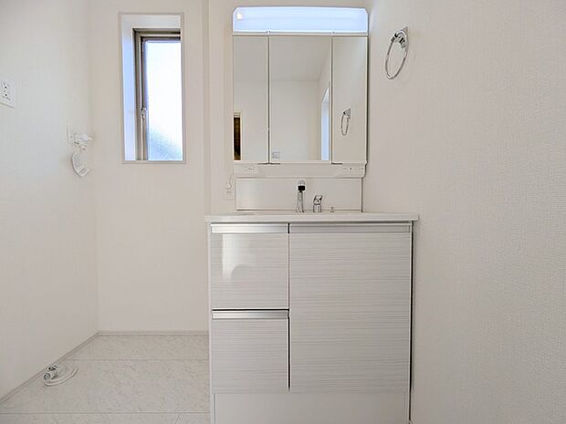 ワイドなボウルにハンドシャワー水栓が付いた洗面化粧台。