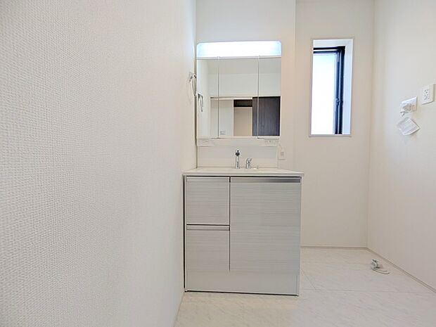 ワイドなボウルにハンドシャワー水栓が付いた洗面化粧台。 