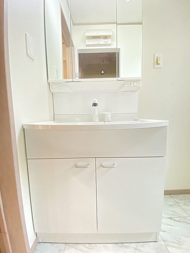 三面鏡を採用した洗面化粧台。鏡の裏にも収納スペースがあります。