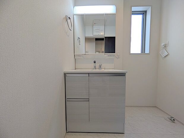 ワイドなボウルにハンドシャワー水栓が付いた洗面化粧台。