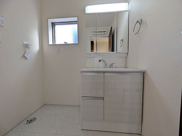 ワイドなボウルにハンドシャワー水栓が付いた洗面化粧台。 