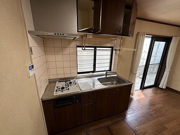 【1階キッチン】作業に集中しやすい壁付キッチンが採用されています。北東側に窓が備わっており、心地よい風を感じながら作業できます。キッチン上下の収納には調理用具やカラトリーなど収納できます。