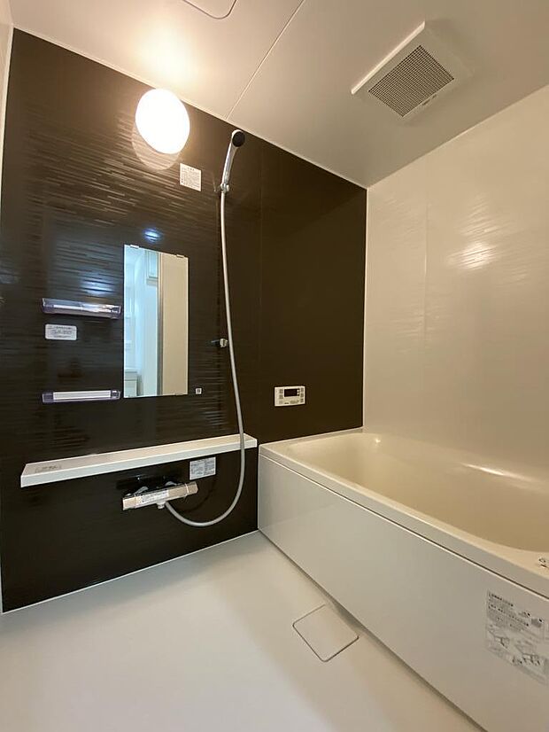 【浴室】毎日の疲れを癒してくれる広々バスルームです。落ち着いたブラウンの壁紙がアクセントになり、ゆったりとした空間でバスタイムを過ごせます。ヘアケア用品など置けるスペースもありとっても便利です◎