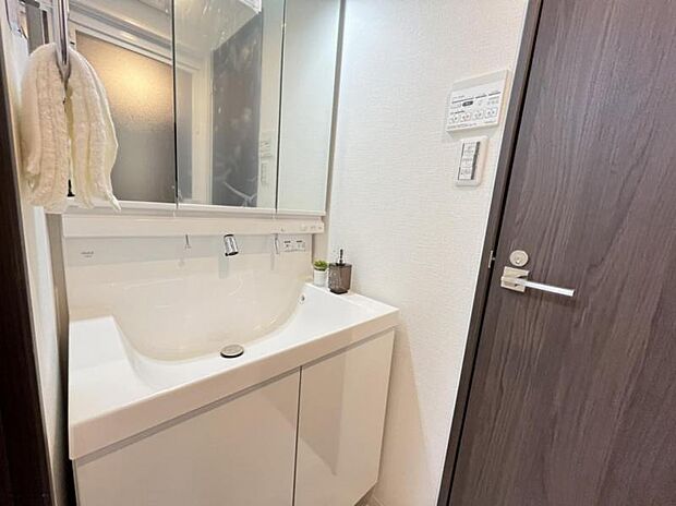 洗顔や手洗いはもちろん、シャンプーも行える多機能洗面台。収納力のある三面鏡を採用することで洗面台周りもスッキリした空間に。