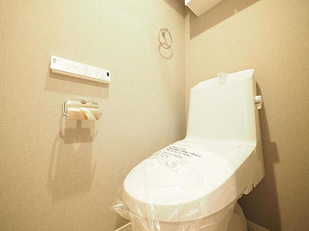 温水洗浄便座付きのトイレです。消耗品などの保管に役立つ棚が備えられています。
