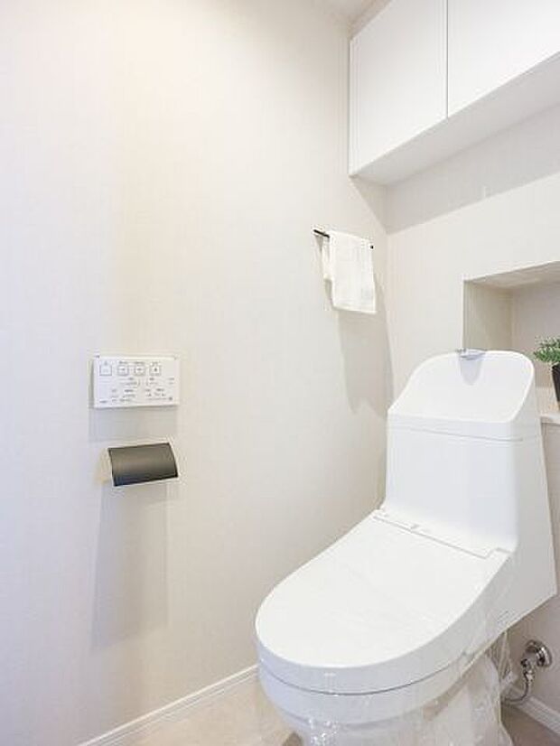 お掃除の手間を減らしてくれる機能が充実したトイレです。備え付けの吊戸棚は、トイレットペーパーや掃除用具などが収納できて便利です。