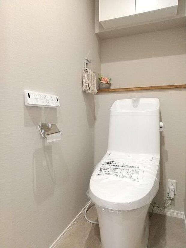 清潔で快適な温水洗浄機能付トイレです。上には吊り棚を設置しており、日用品を収納できます。 