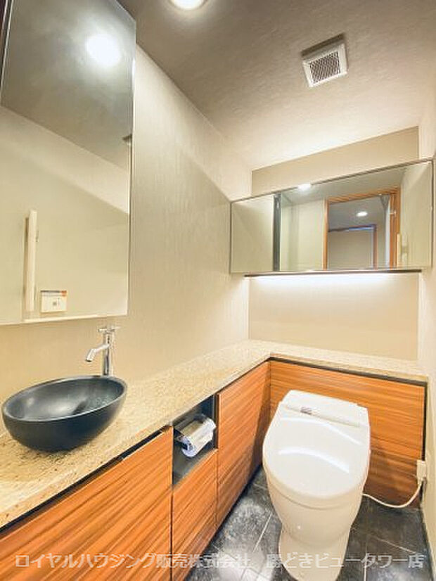 天然石仕様の床材、タンクレス・手洗いカウンター付きトイレ
