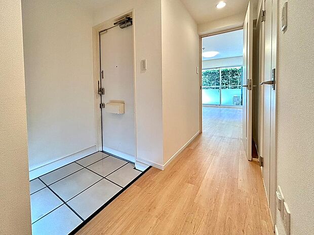 ―玄関　写真―白いタイルと玄関ドア、SHOESBOXが清潔感と広さを感じます。廊下も広く高級感も感じます。