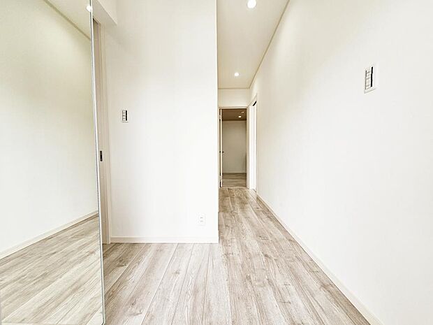 【廊下】クロスとフローリングの張替えを行いました。床の木目と新品の白基調の建具がマッチする明るい場所に生まれ変わりました。