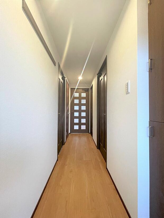 【リフォーム済】廊下の写真です。床はクッションフロアを上張りし、天井壁クロスは張り替えました。ダウンライト照明も新品交換したので明るい廊下になっています。