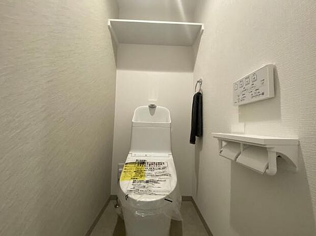 操作パネルが壁面についたトイレです。タンク一体型でスッキリとした印象です。