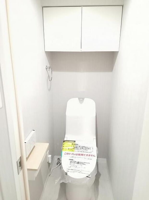 リモコンタイプのシャワー付トイレ。吊戸棚を設置しましたのでトイレ用品・在庫など収納できます。