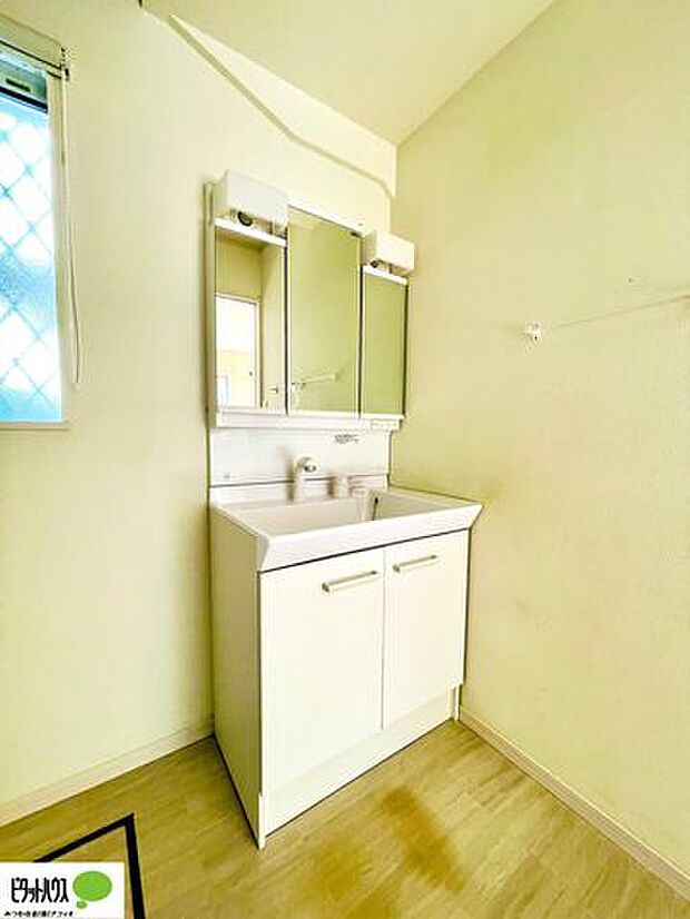 使い勝手のいい三面鏡。24時間換気の換気扇と窓があり清潔感のある洗面室です。