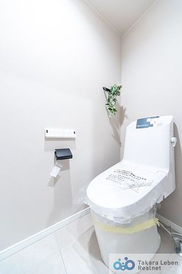 落ち着いた壁紙で清潔感のあるトイレ。トイレットペーパーホルダーとタオル掛けは標準で実装してます。