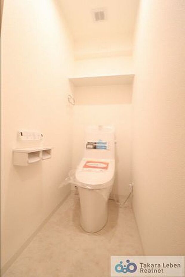 白を基調に清潔感のあるトイレ。トイレットペーパーホルダーとタオル掛けは標準で実装してます。上部に棚があり、掃除用具などの収納場所に困りません。