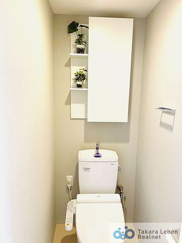 吊戸棚付き温水洗浄トイレ。飾り棚も設けられており、オシャレにデコレーションが出来ます。