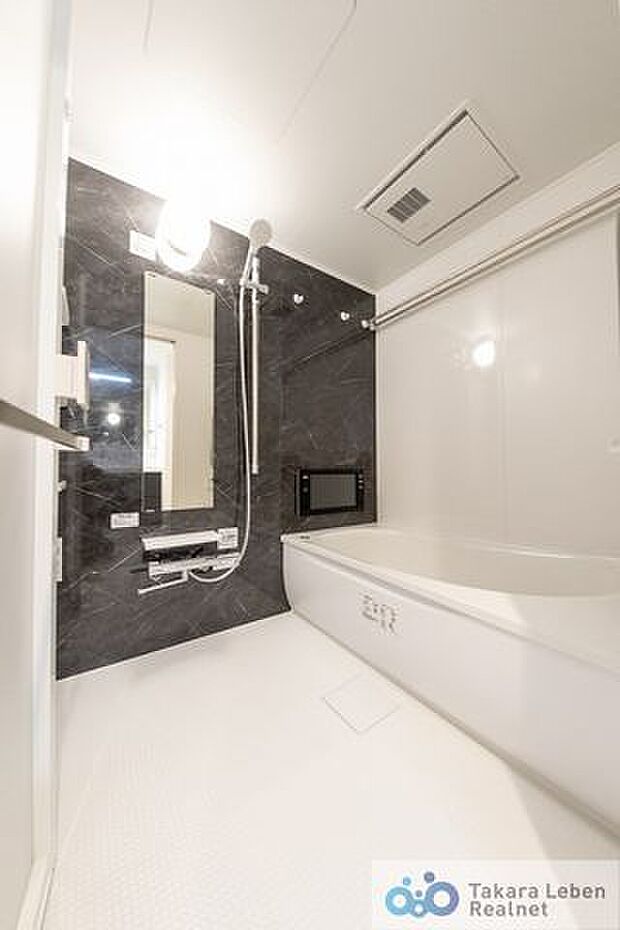 シックなブラウンのアクセントパネルを使用しシンプルかつ、清潔さを感じさせるバスルーム。