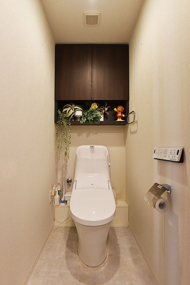 トイレの上部には吊戸棚付き。備品や清掃用品もすっきり収納できますね。