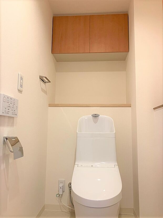 温水洗浄便座付きのお手洗いです。吊戸棚、カウンター付きで収納に便利です。
