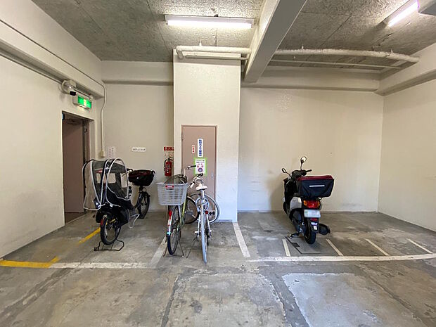 【駐輪場・バイク置き場】屋内駐輪場・バイク置き場です。区画が白線で整理されていて、大型自転車やミニバイクも停めやすいですね。空き状況や月額利用料はお尋ねください♪防犯カメラが設置されていて安心です◎