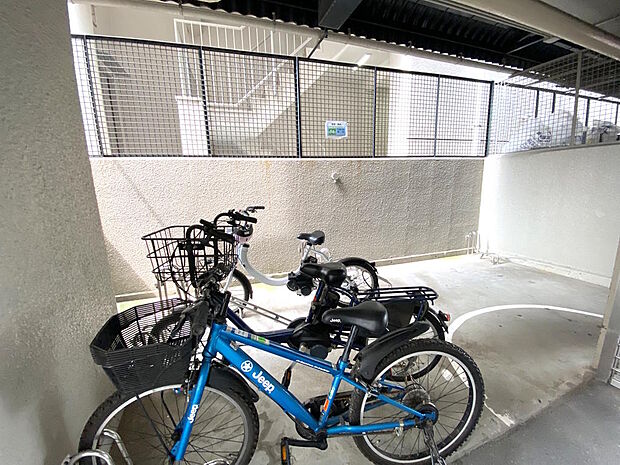 【駐輪場】１階にある駐輪場です。屋根があり、雨から自転車を守れますね。２階エントランスまでの行き来は階段とエレベーターと２つ方法があります。空き状況や月額利用料金については都度確認が必要です。