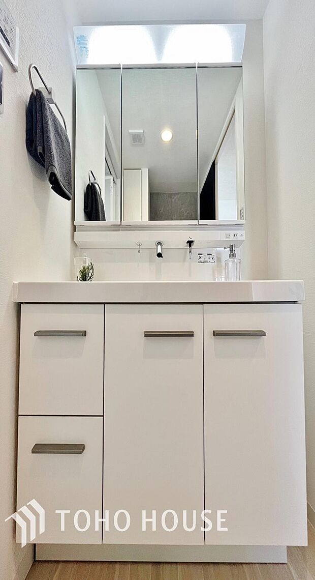 「シャワー機能付き。三面鏡洗面台」洗面台には三面鏡を採用。鏡の後ろに収納スペースが設けられているので、洗面台周りをスッキリと片付ける事ができます。