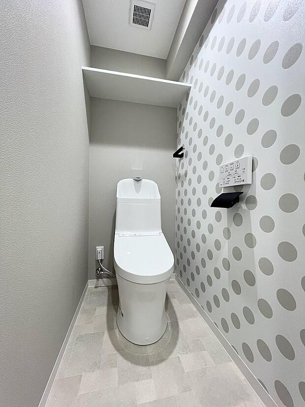 トイレも水玉模様ながらもグレーを使って可愛くオシャレに♪温水洗浄便座付。トイレットペーパーや掃除用具を収納できる棚もございます。