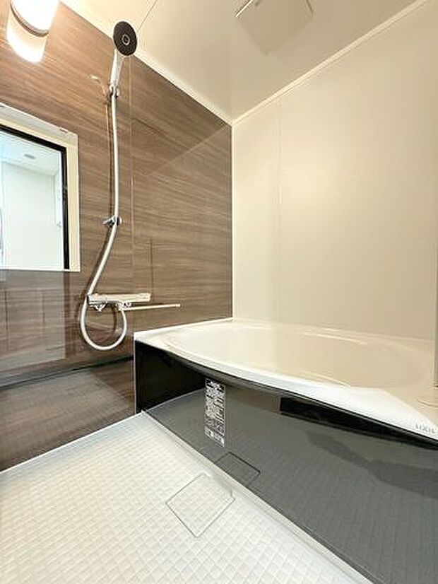 《浴室》濃い木目調のアクセントパネル、ブラックの浴槽を採用し、高級感のある浴槽になりました。